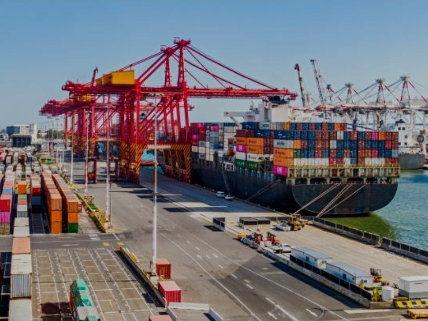 Terminal de contenedores con grúas rojas y un buque atracado